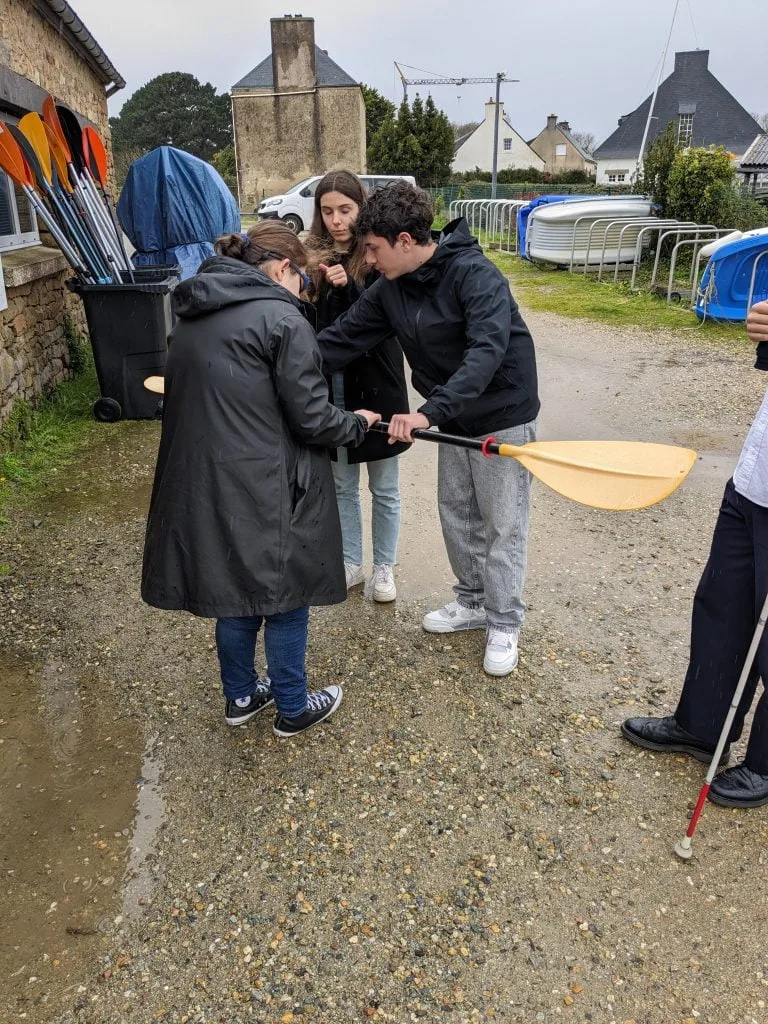 SFX_ESAT_3 Trois personnes présentant l'utilisation d'une pagaie de kayak.