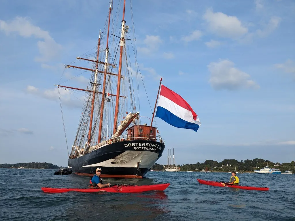 Kayaks monoplaces naviguant autour des vieux gréements de la Semaine du Golfe du Morbihan.