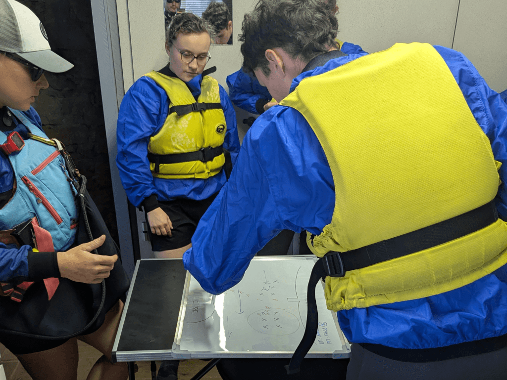 Préparation de la sortie avec des scolaires sur une carte marine lors d'un cycle scolaire kayak.